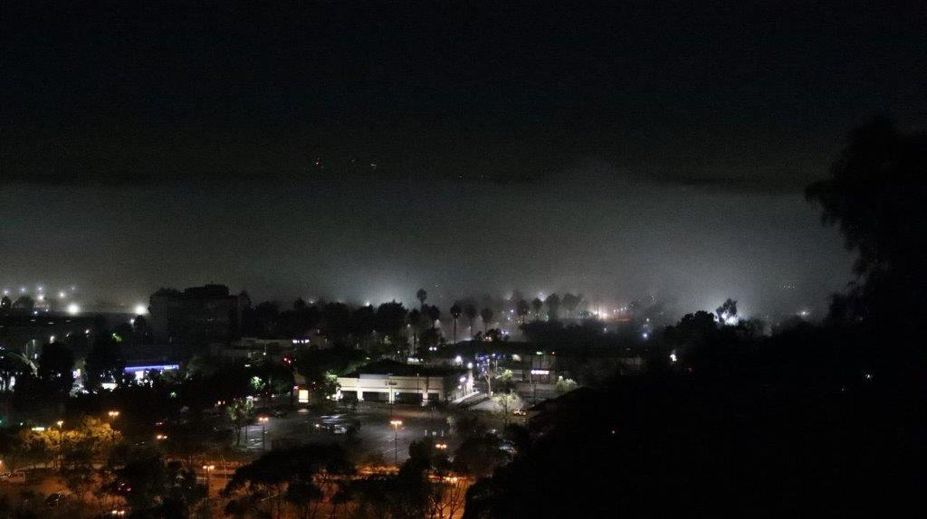 A city at night with fog

Description automatically generated