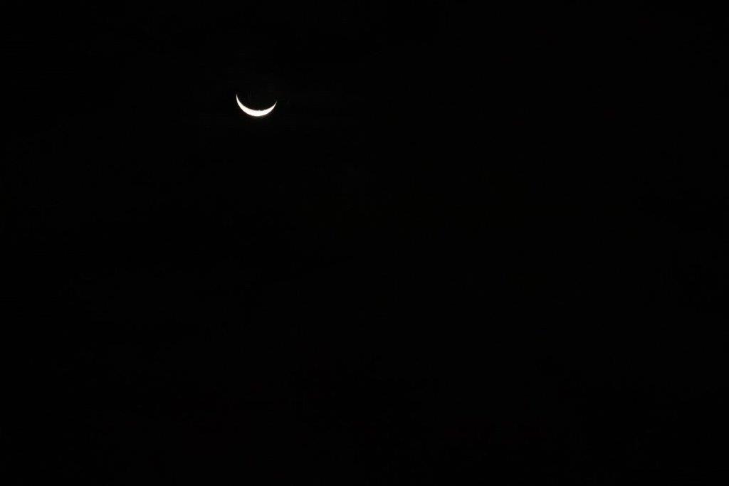 A crescent moon in the night sky

Description automatically generated