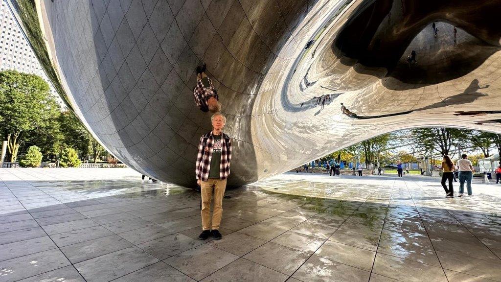 A person standing under a large metal object

Description automatically generated