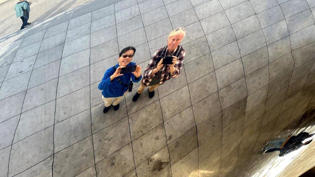 Two people standing on a tiled surface

Description automatically generated