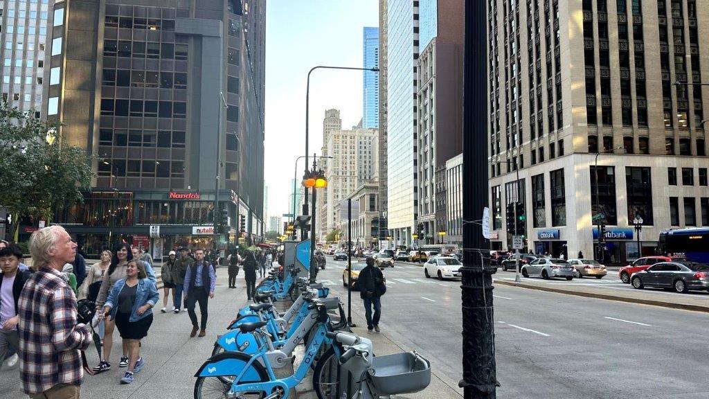 A group of blue bicycles parked on a sidewalk

Description automatically generated