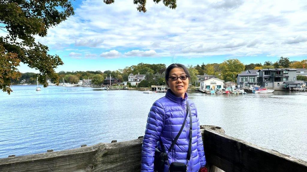 A person standing on a bench by a body of water

Description automatically generated