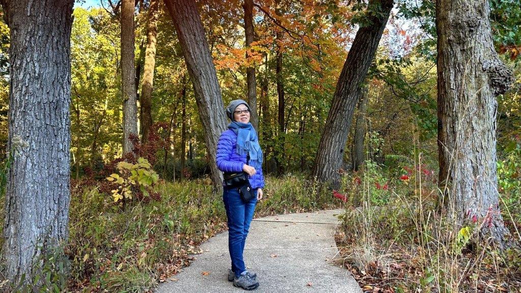 A person standing on a path in the woods

Description automatically generated