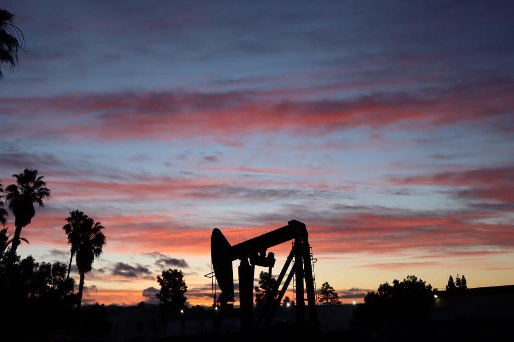 A silhouette of a pumpjack

Description automatically generated