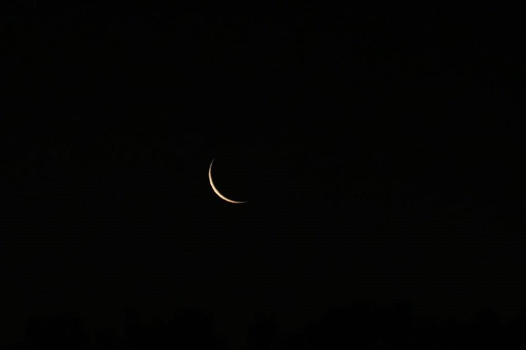 A crescent moon in the night sky

Description automatically generated