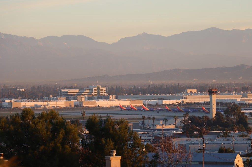 A view of an airport with mountains in the background

Description automatically generated