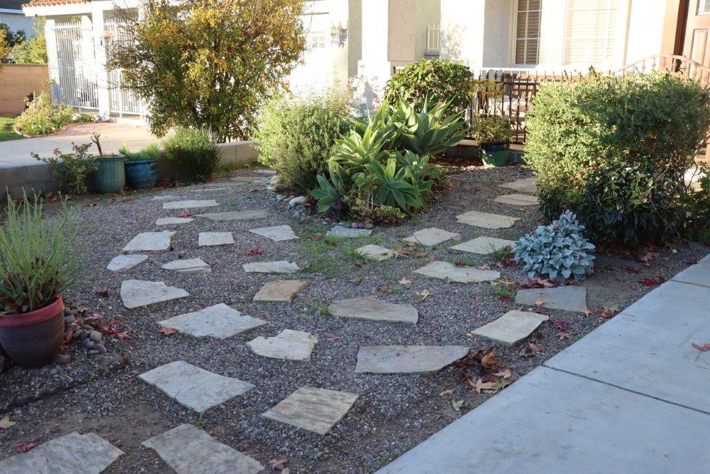 A stone path in front of a house

Description automatically generated