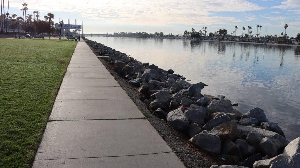 A sidewalk next to a body of water

Description automatically generated