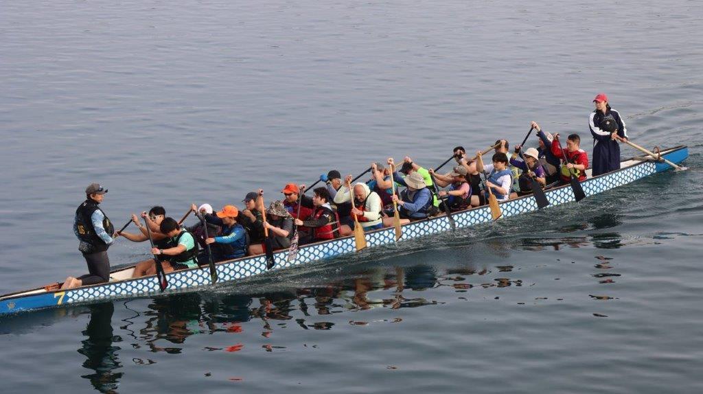 A group of people rowing a boat

Description automatically generated