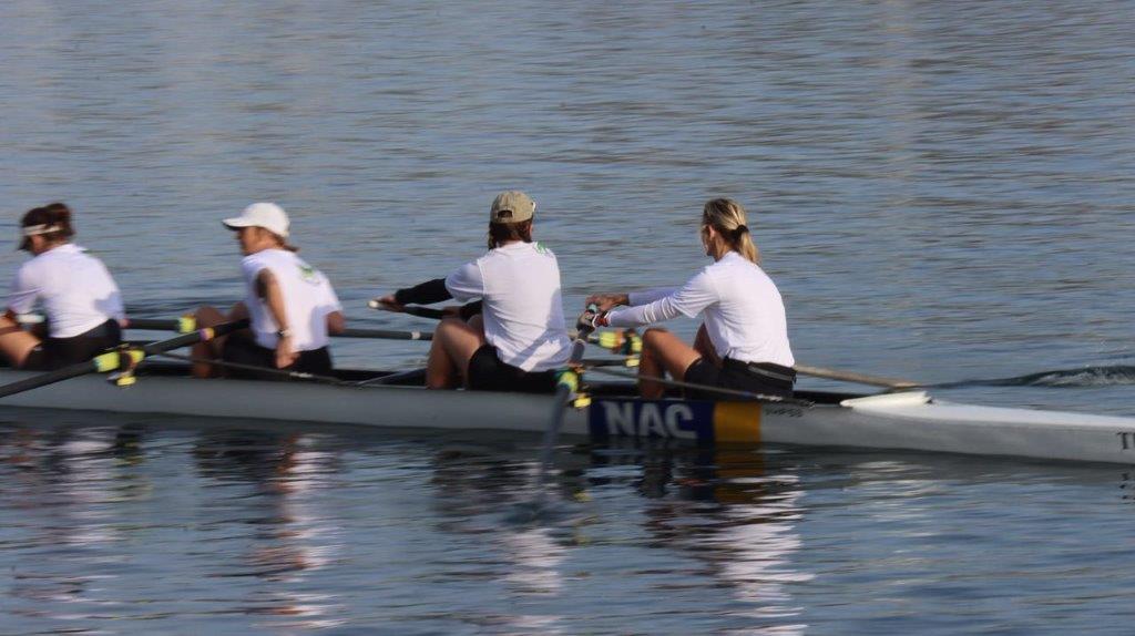 A group of people rowing a boat

Description automatically generated