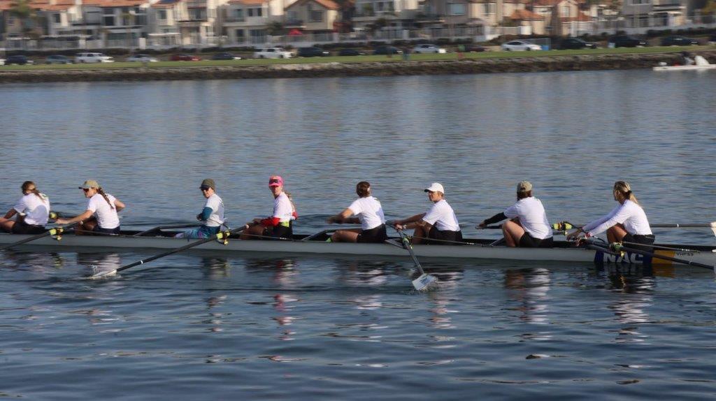 A group of people rowing a boat

Description automatically generated