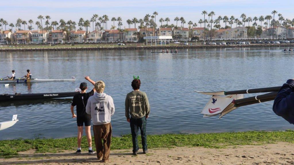 A group of people standing on a beach looking at a plane

Description automatically generated