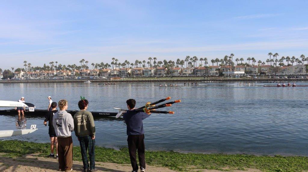 A group of people standing by a body of water

Description automatically generated