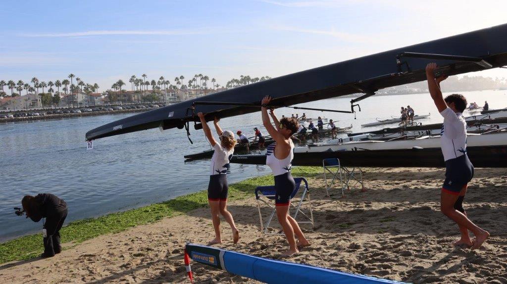 A group of people lifting a boat

Description automatically generated