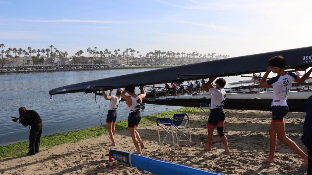 A group of people lifting a kayak

Description automatically generated