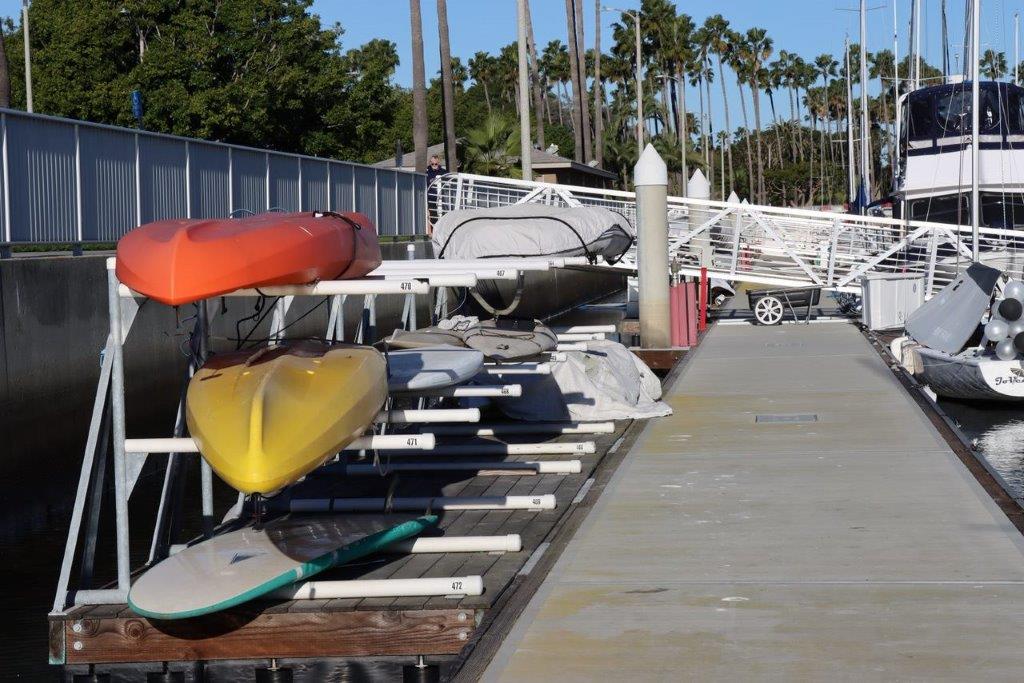 Kayaks on a rack next to a dock

Description automatically generated