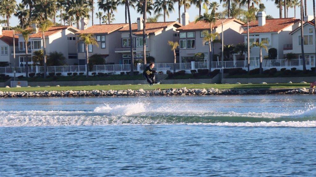 A person on a wakeboard in front of a house

Description automatically generated