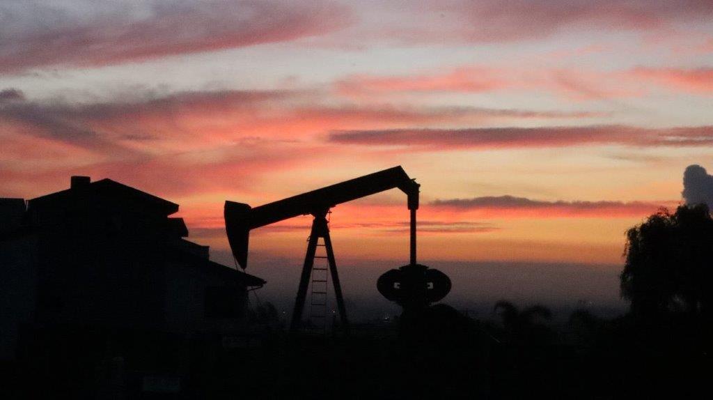 A silhouette of a pumpjack

Description automatically generated