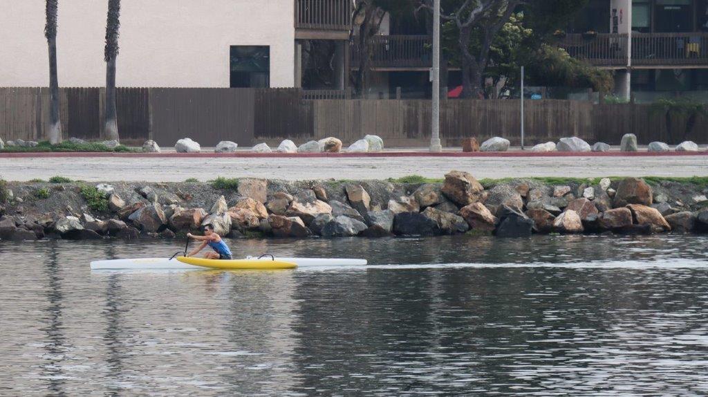 A person in a yellow kayak on a lake

Description automatically generated
