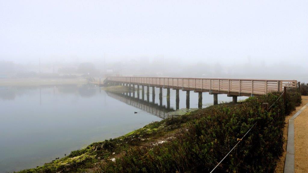 A bridge over water with fog

Description automatically generated