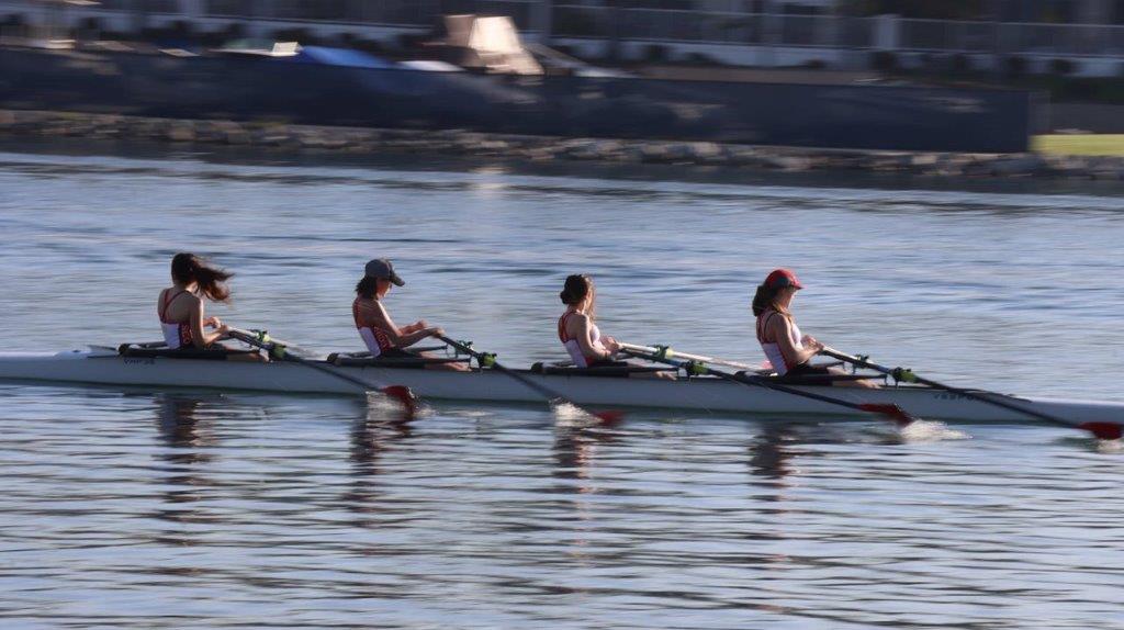 A group of women rowing on the water

Description automatically generated