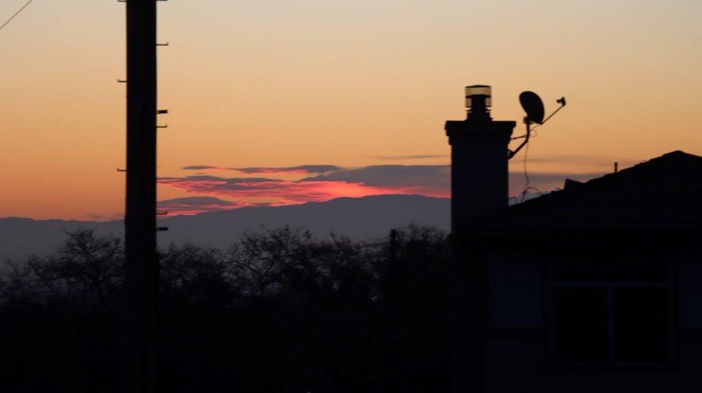 A silhouette of a chimney and a sunset

Description automatically generated