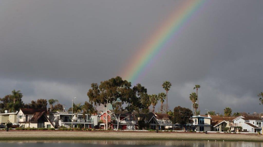 A rainbow over a neighborhood

Description automatically generated