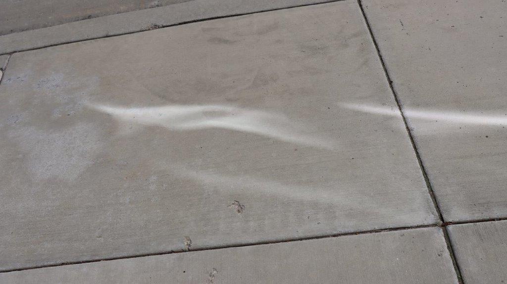 A grey tile on a sidewalk

Description automatically generated