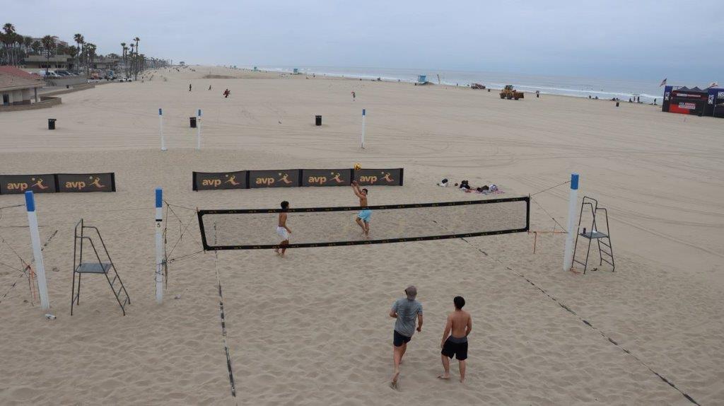 A group of people playing volleyball on a beach

Description automatically generated