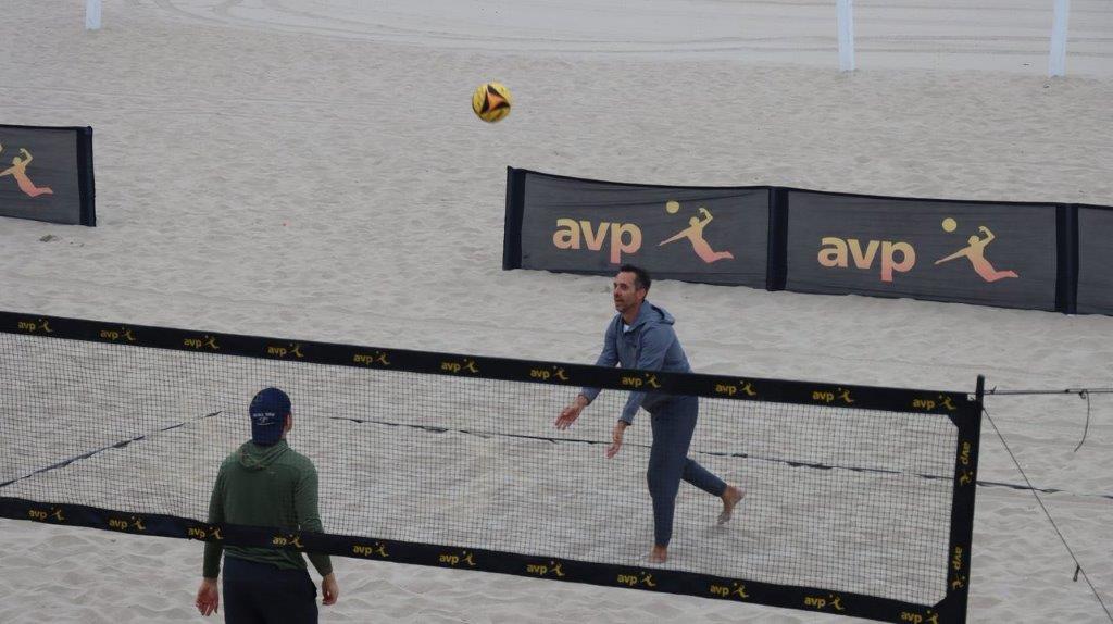 A person playing volleyball on a beach

Description automatically generated
