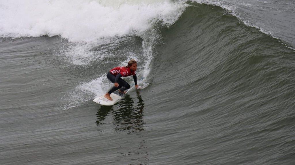 A person on a surfboard riding a wave

Description automatically generated