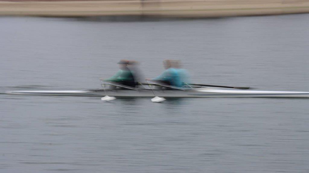 A blurry image of people rowing on a lake

Description automatically generated