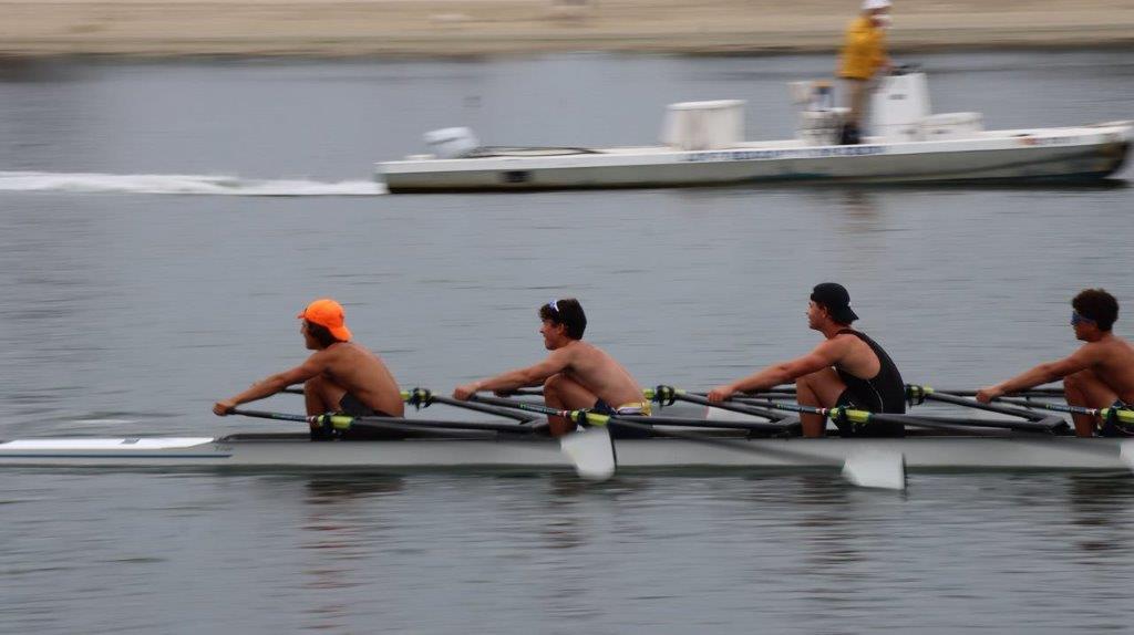 A group of men rowing a boat

Description automatically generated