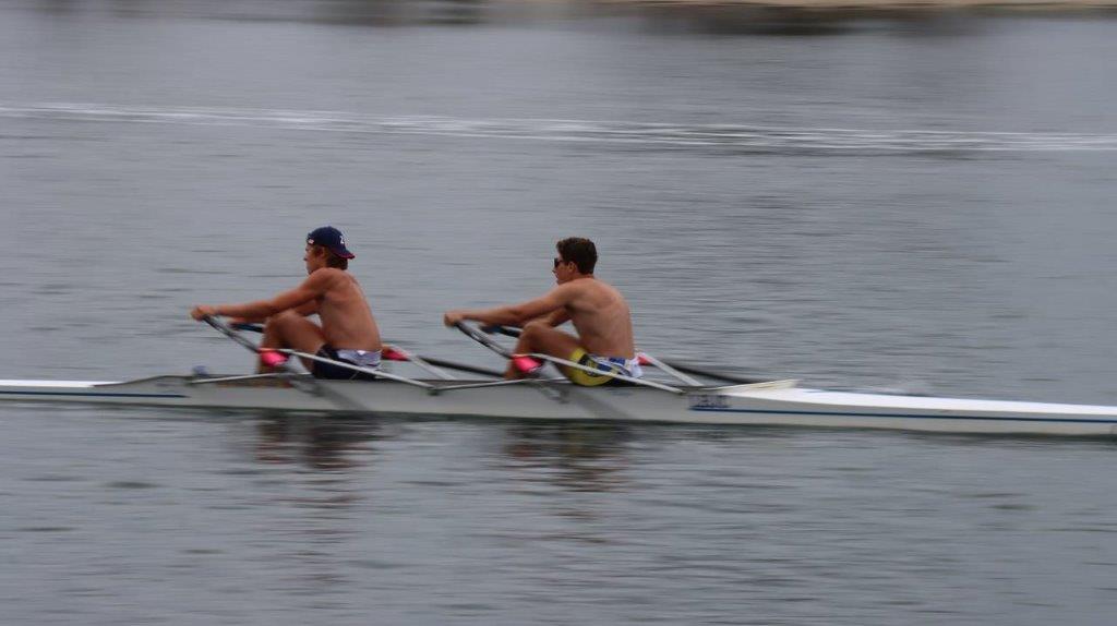 A group of men rowing on a lake

Description automatically generated