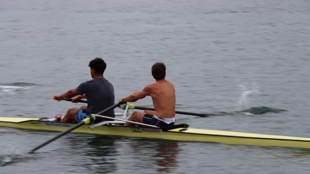 A couple of men rowing in a boat

Description automatically generated