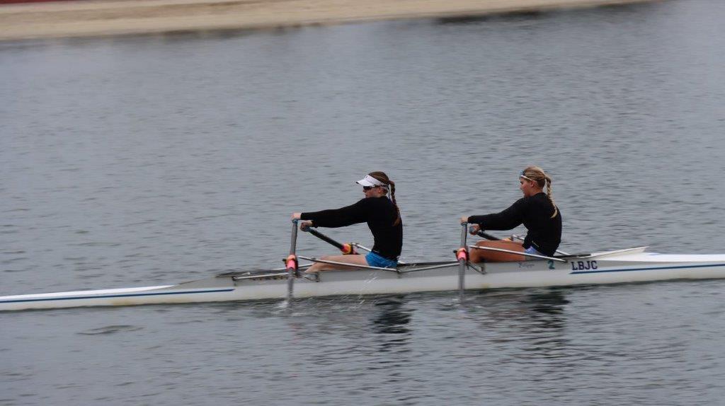 A couple of women rowing on a boat

Description automatically generated