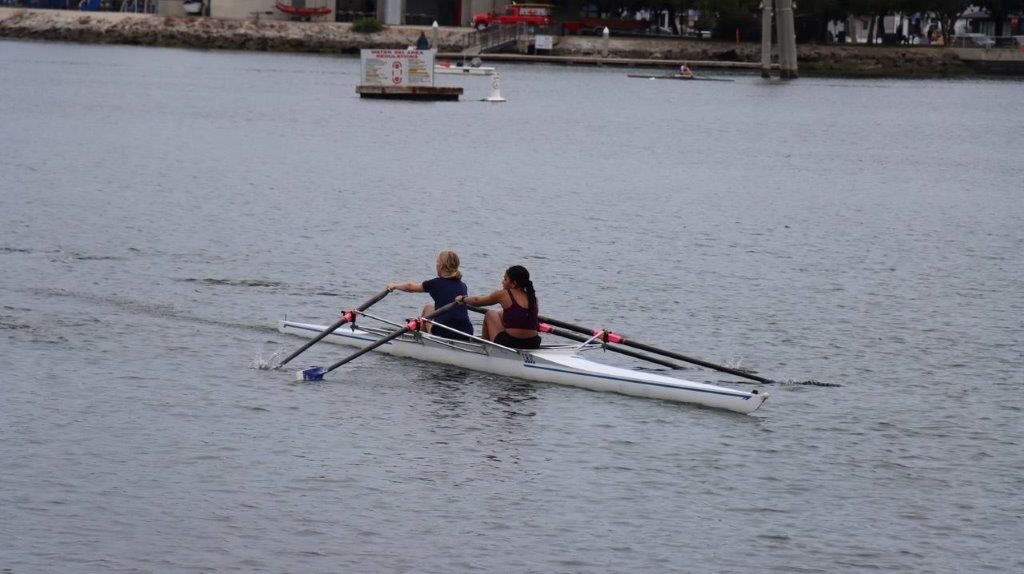 A couple of women rowing a boat

Description automatically generated