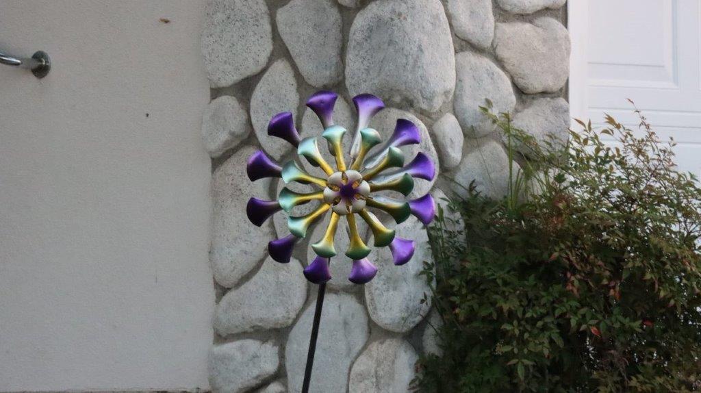 A colorful pinwheel in front of a stone wall

Description automatically generated