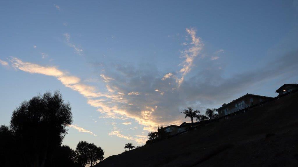 A blue sky with clouds and a house

Description automatically generated