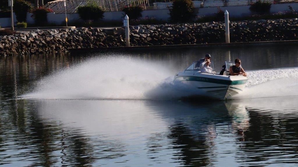 A speedboat driving on a lake

Description automatically generated