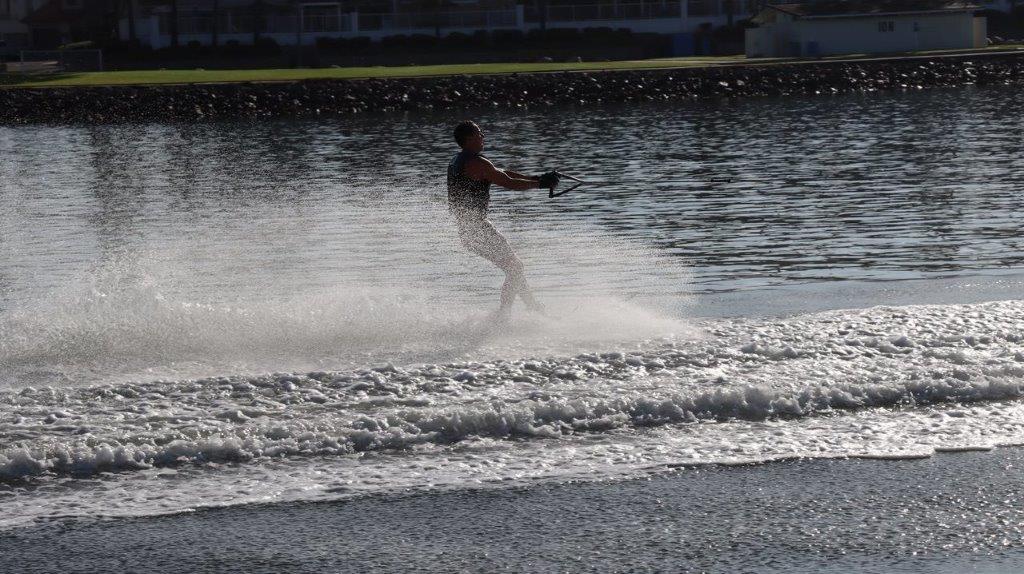 A person water skiing on a lake

Description automatically generated