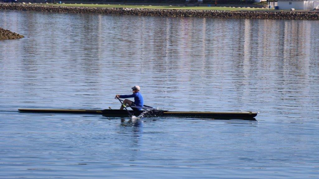 A person rowing a boat on a lake

Description automatically generated