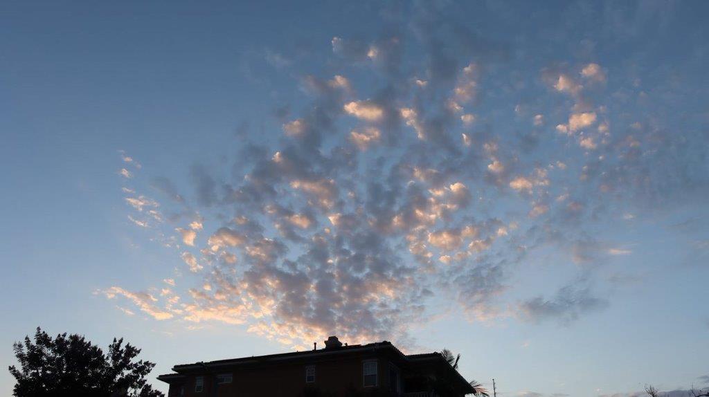 A house with clouds in the sky

Description automatically generated