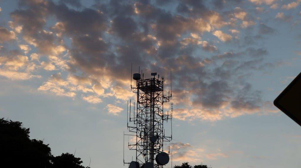 A tower with antennas and clouds in the sky

Description automatically generated