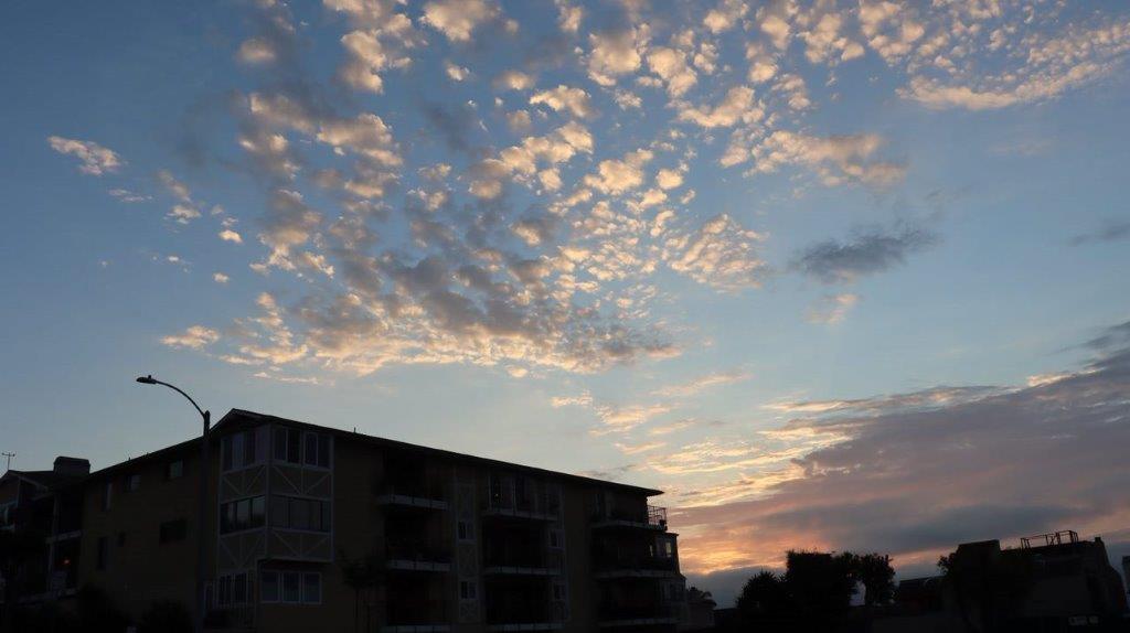 A building with clouds in the sky

Description automatically generated