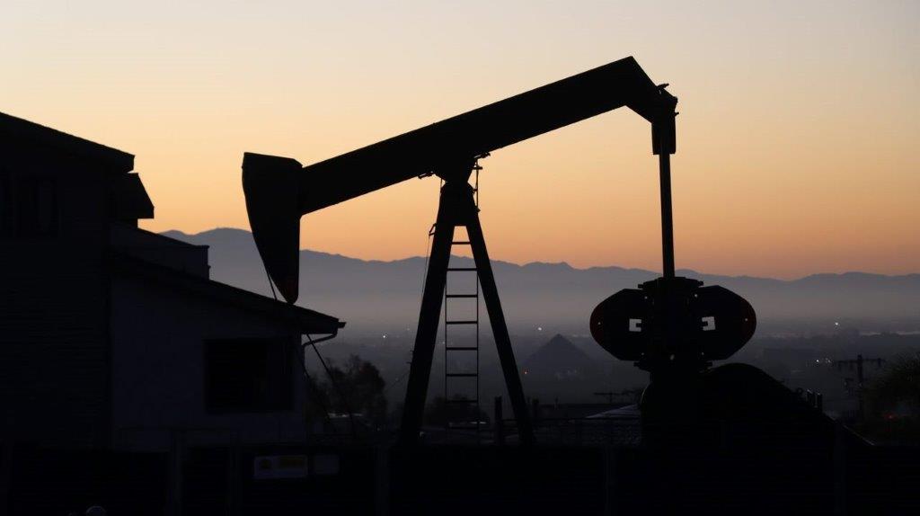 A silhouette of a pumpjack

Description automatically generated