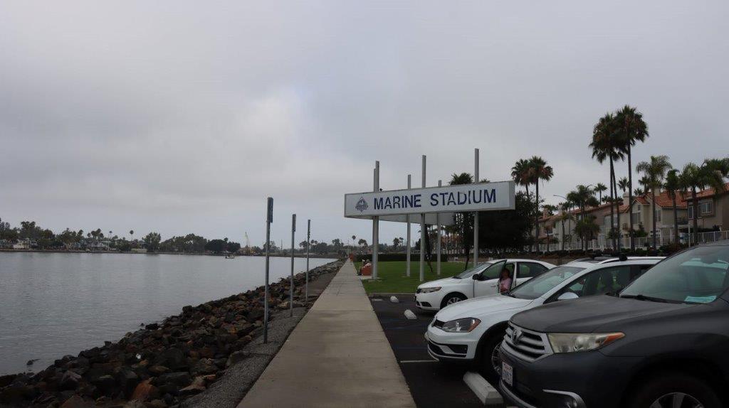 A parking lot with cars parked next to a body of water

Description automatically generated