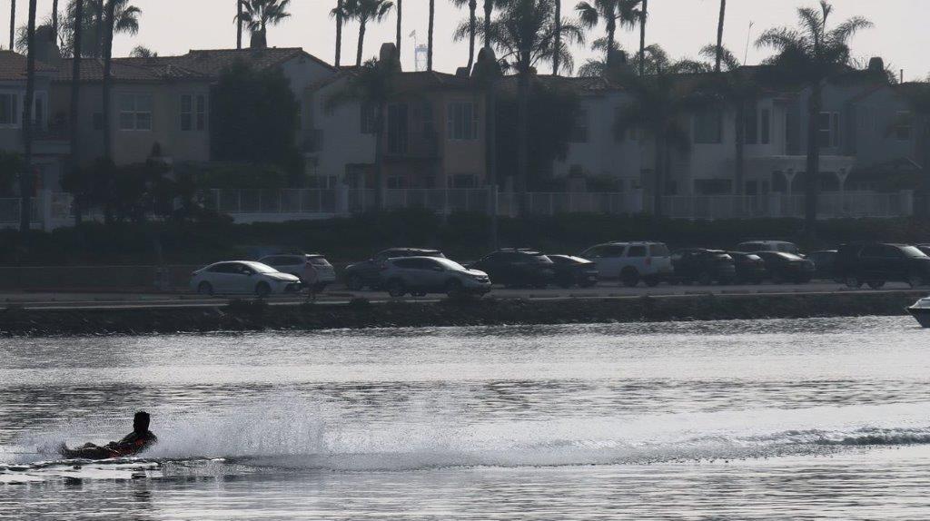 A body of water with cars in the foreground

Description automatically generated